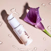 Lubrifiant Lube de Bouche Bée avec texture sur fond et une fleur à côté - Gapianne
